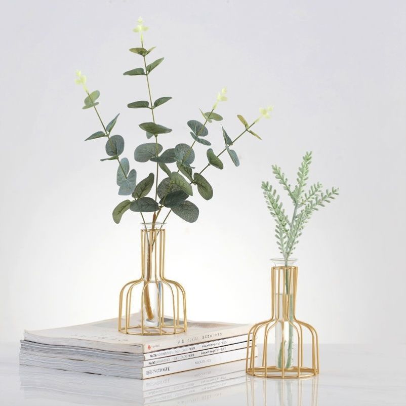 Geometric iron bud vase with glass test tube insert holding a single stem — scale view