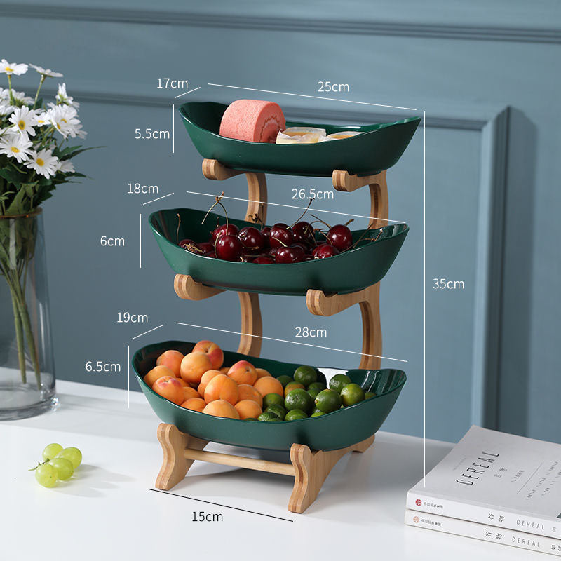 Tiered fruit and dessert stand styled with fresh fruit on kitchen counter — view 7