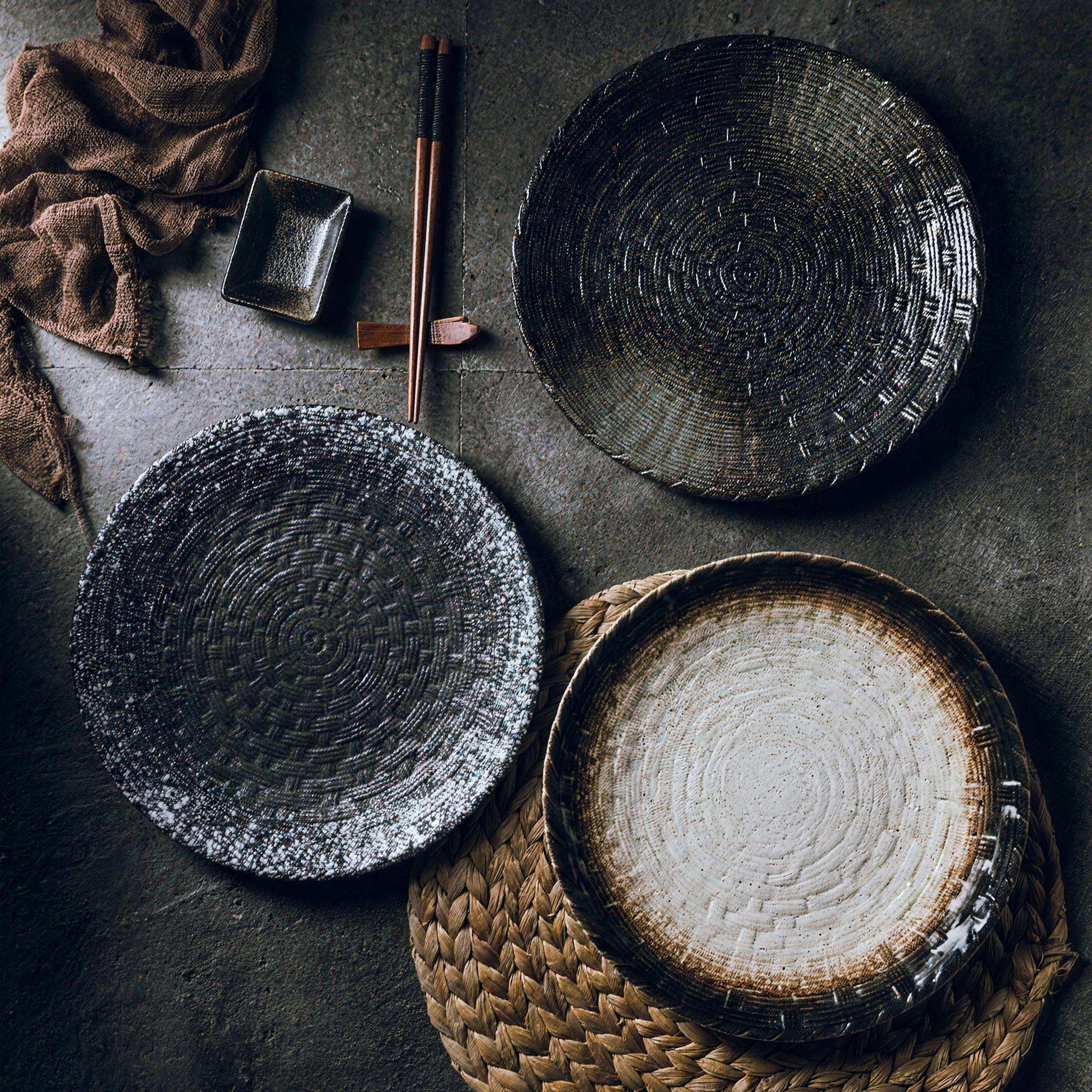Woven-texture glazed ceramic dinner plate in black on a set table — alternate view