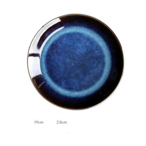 Kiln-glazed blue porcelain shallow dish on a neutral table