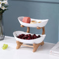 Tiered fruit and dessert stand styled with fresh fruit on kitchen counter — alternate view