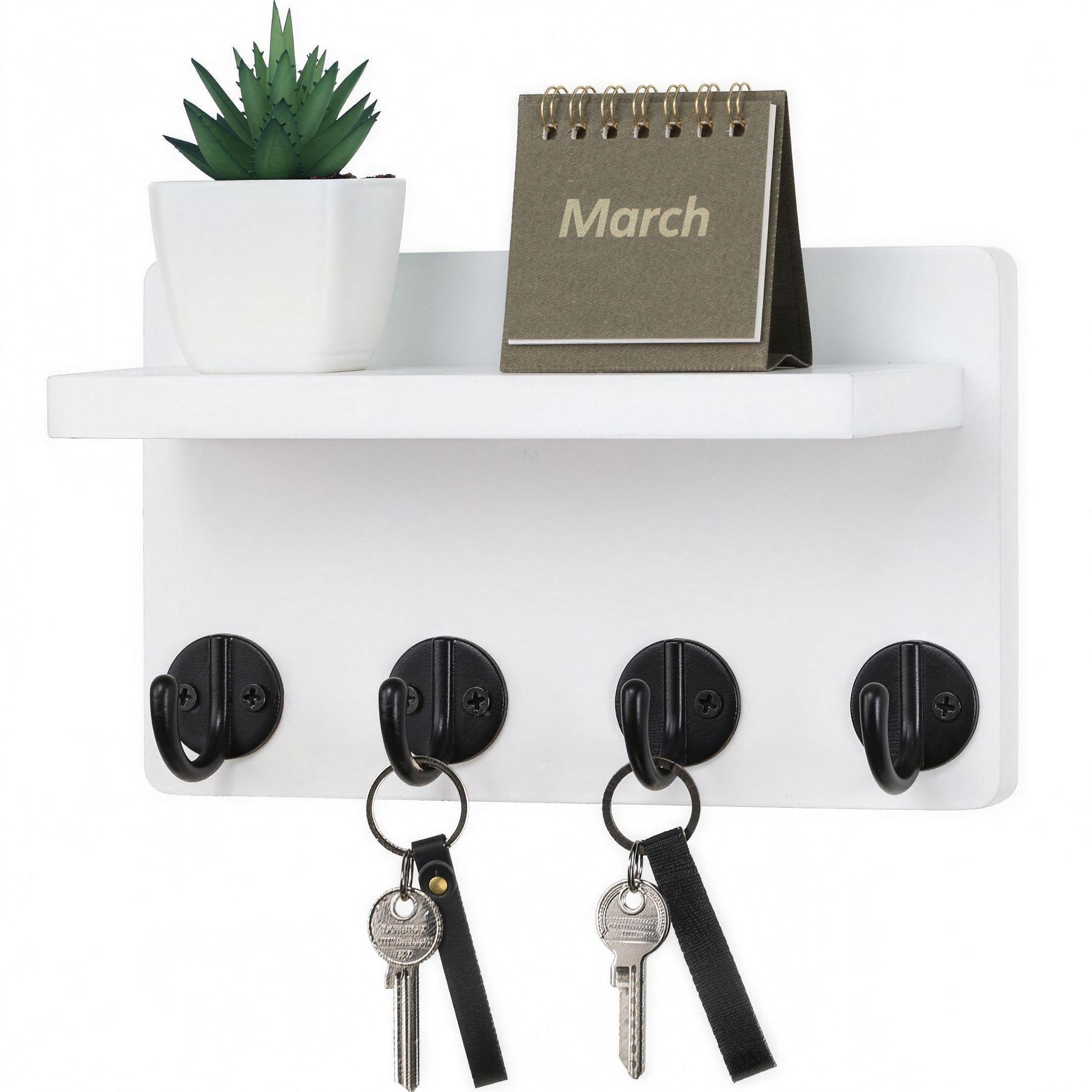White wooden wall-mounted key holder with hooks and display shelf in entryway