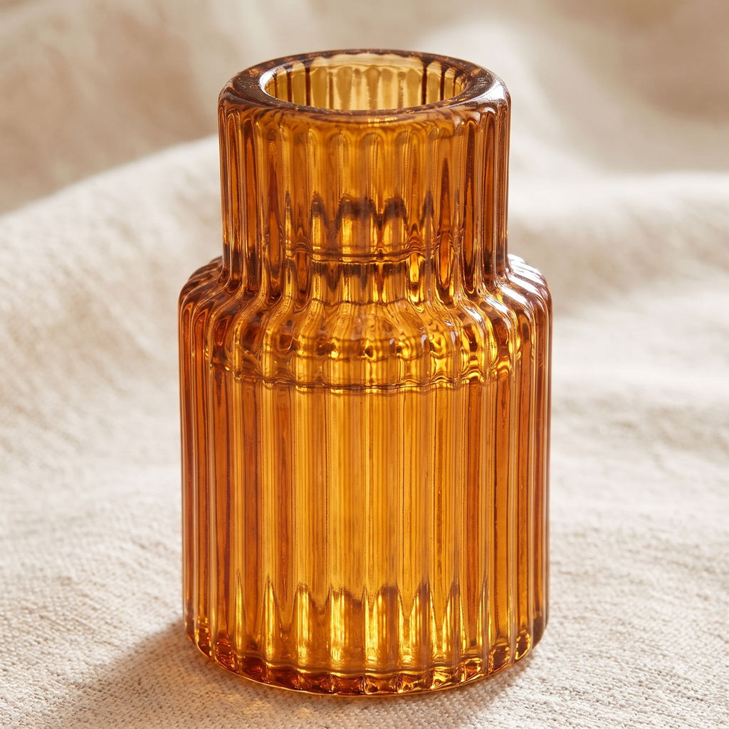 Amber ribbed glass taper candle holder detail showing the ribbed glass texture backlit