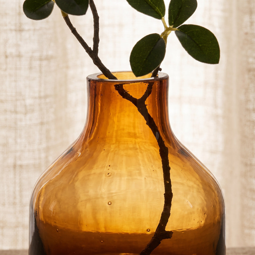 Handblown amber glass bud vase detail backlit showing the glass colour and thickness