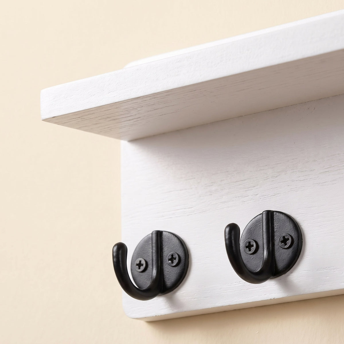 Wooden key holder detail showing the hooks and shelf edge