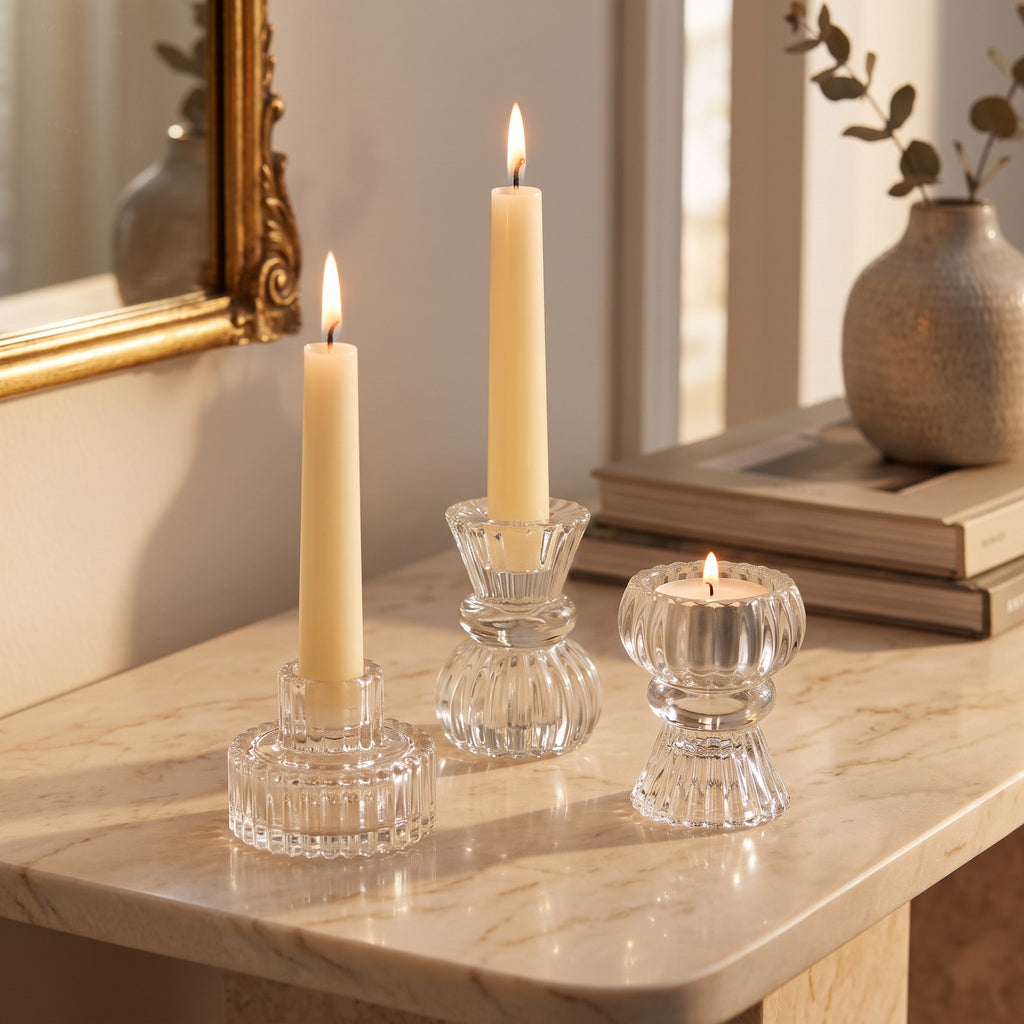 Reversible ribbed glass candle holders in three heights with lit candles on marble