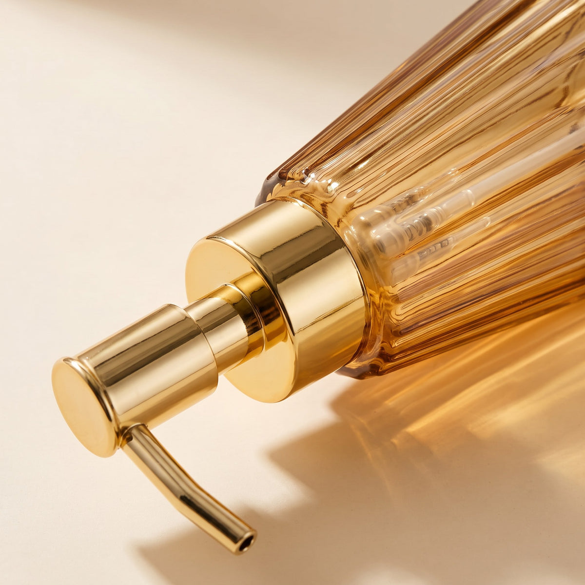 Amber glass soap dispenser detail showing the pump and glass colour