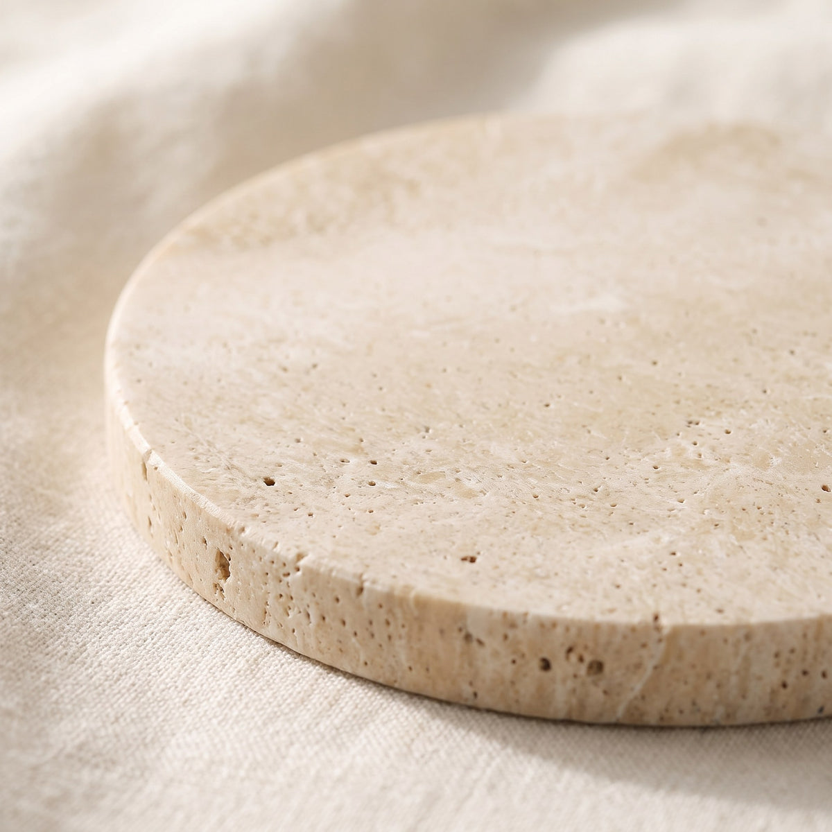 Natural travertine coaster detail showing the porous stone texture and edge